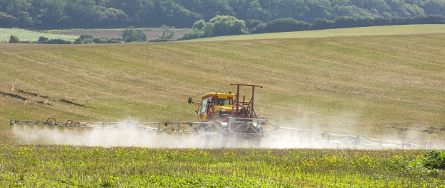 A tractor spraying fertiliser in a field
